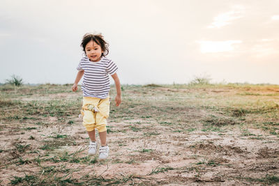 Full length of boy walking on field