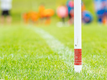 Corner kick spot on grass football stadium, players in blue and orange stretching out of focus.