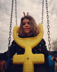 Portrait of happy girl on swing in playground