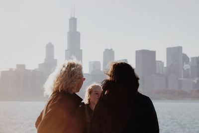 People standing by cityscape against sky