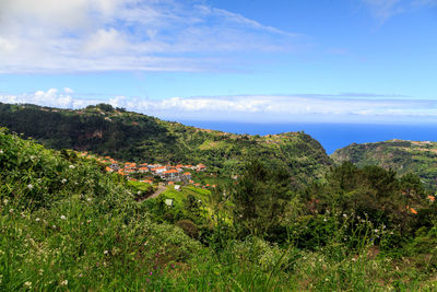 Scenic view of townscape by sea against sky