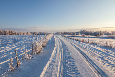 Snow covered field against sky