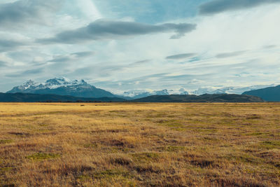 Scenic view of field and mountains against sky