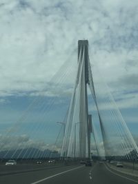 View of suspension bridge against cloudy sky