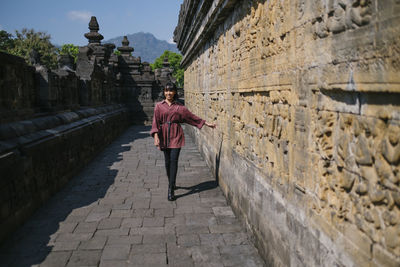 Full length rear view of man walking in historic building