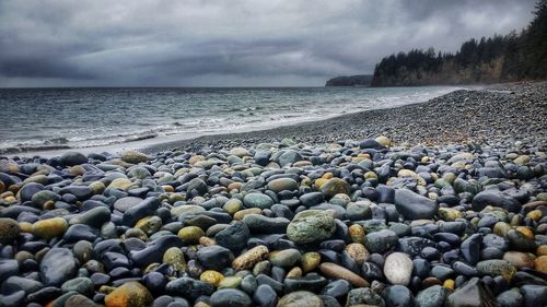 Pebbles on beach against sky