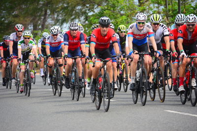 Group of people riding bicycle on road