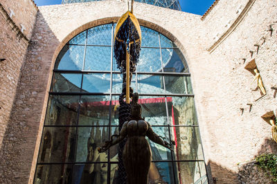 Rear view of woman standing against building