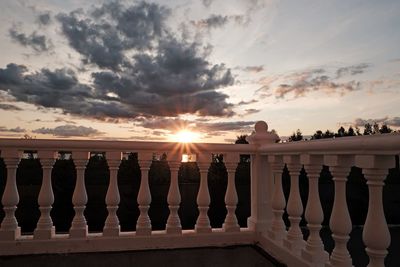 Built structure on sea against sky during sunset