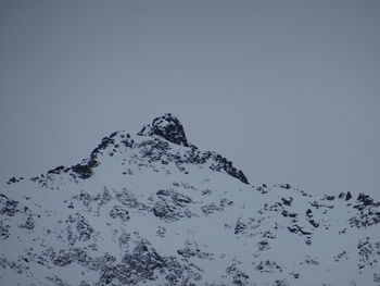 Low angle view of snowcapped mountain against clear sky