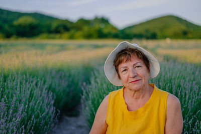 Portrait of young woman standing on field