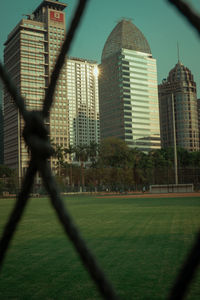 Buildings seen through chainlink fence