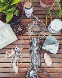 High angle view of dreamcatchers with plant and candle on table