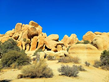 Rock formations against clear blue sky