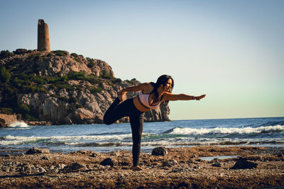 Side view of woman standing at beach