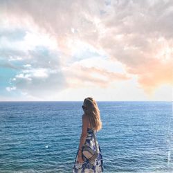 Man standing in sea against sky