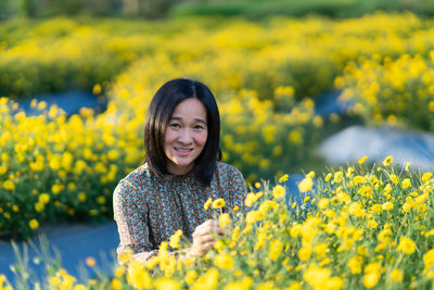 Portrait of smiling young woman standing on field