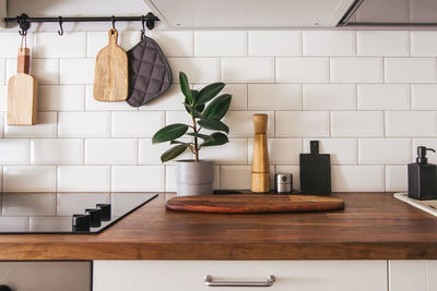 Kitchen brass utensils, chef accessories. hanging kitchen with white wall and wood tabletop.