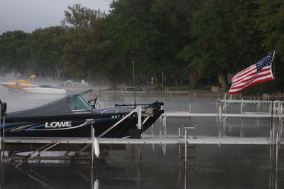 Boats moored in lake against trees