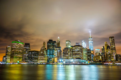 Illuminated buildings in city against sky at night