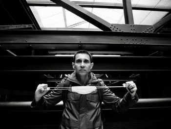 Portrait of young man standing against ceiling