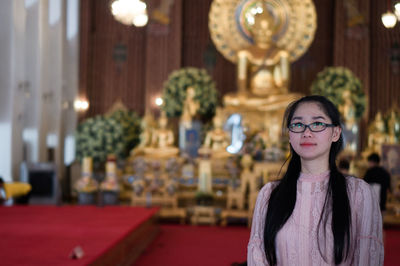 Portrait of woman standing in buddhist temple