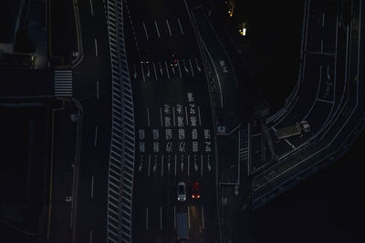 Low angle view of illuminated lighting equipment on building at night