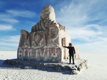 Man standing by old ruin at desert