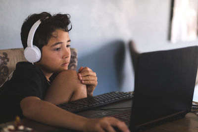 Boy doing his homework on laptop