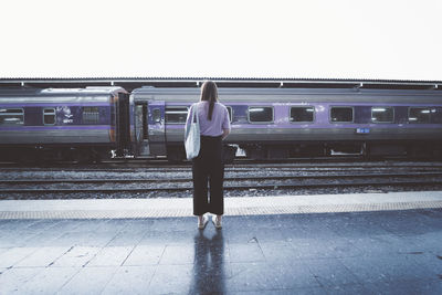 Rear view of woman on train at railroad station platform