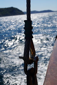 Close-up of rope tied on bollard against sea