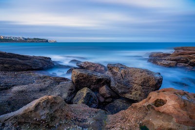 Rocks on beach against sky