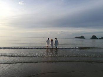 People on beach against sky