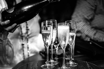 Midsection of bartender pouring champagne