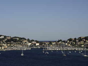 Sailboats in sea against clear sky