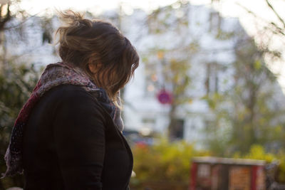 Rear view of woman standing against trees