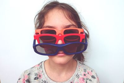 Portrait of girl wearing sunglasses against white background