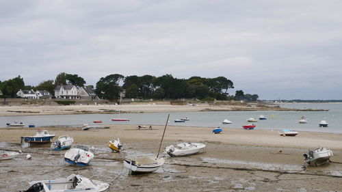 Boats moored on beach against sky