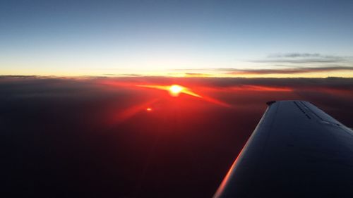 Airplane flying in sky during sunset