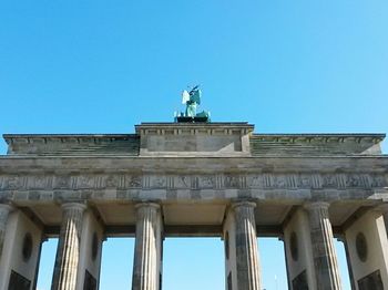 Low angle view of historical building against clear blue sky