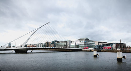 Bridge over river against sky in city