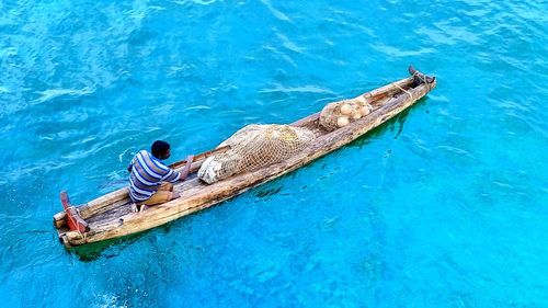 High angle view of man sitting in boat on sea