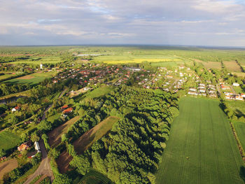 High angle view of agricultural field by sea against sky