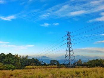 Electricity pylon on field against sky