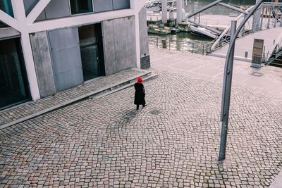 Woman walking on footpath in city