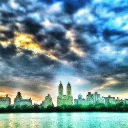 Cityscape against cloudy sky at sunset