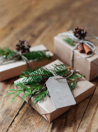 Christmas presents in craft paper with natural decoration. wooden table with new year gifts.