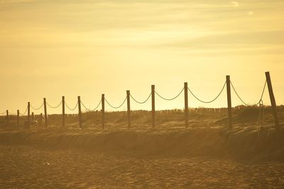 Bridge over sea against sky during sunset