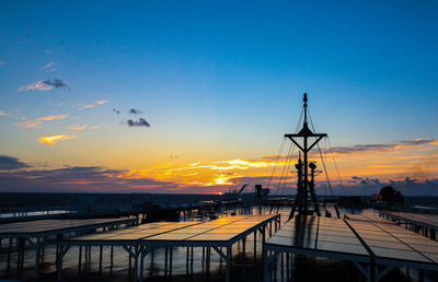 Silhouette pier over sea against sky during sunset