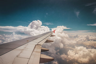 Cropped image of airplane wing flying against sky